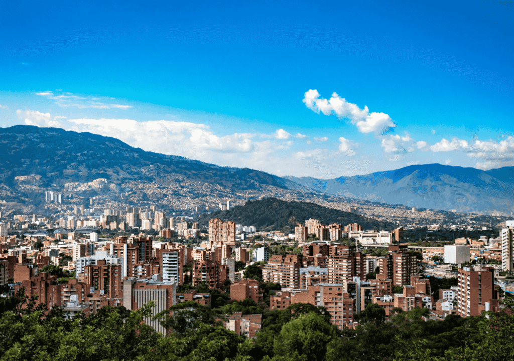 Medellín city skyline with lush mountains in the background under a clear blue sky